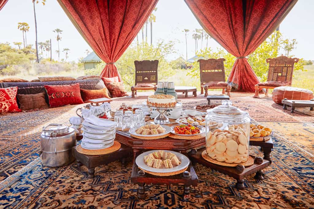 A swimming pool shaded by a pavilion-style tent. 