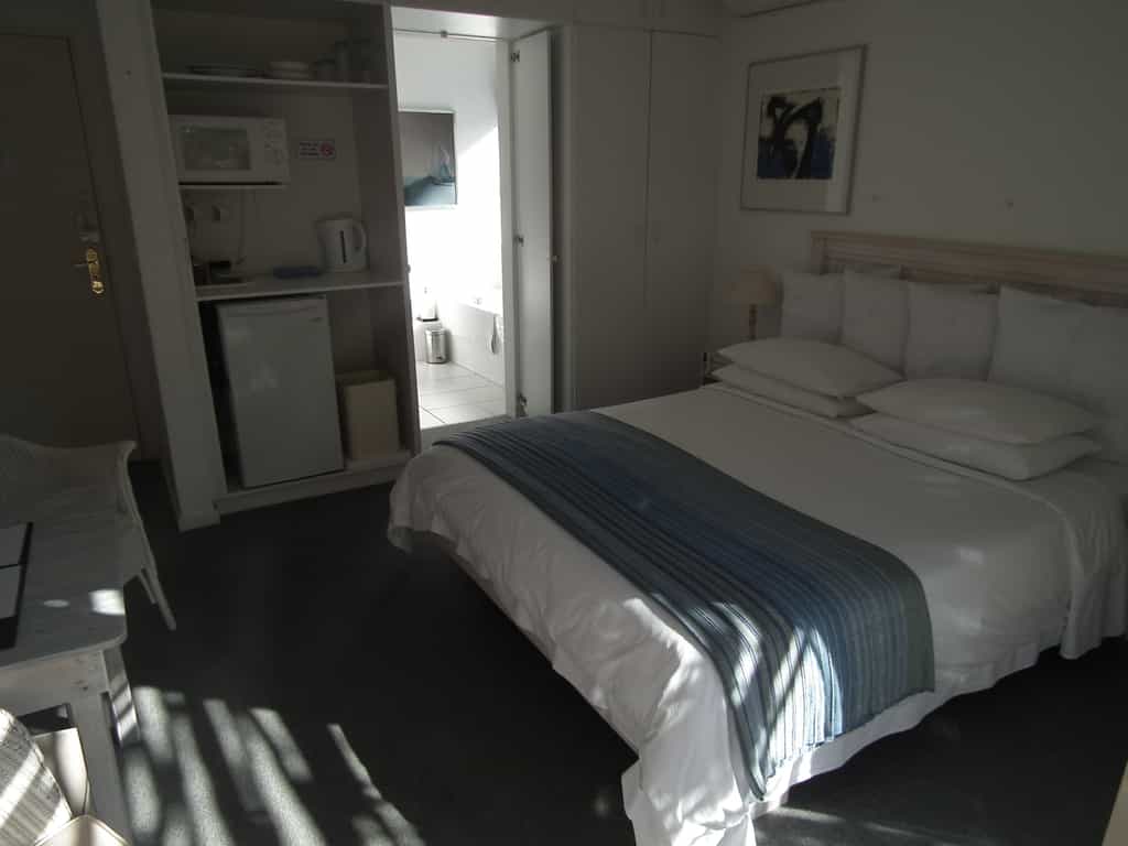 King size bed, full en-suite bathroom (bath & shower), private wooden deck with direct access to solar heated pool, unobstructed view of mountain and Fernkloof Nature Reserve