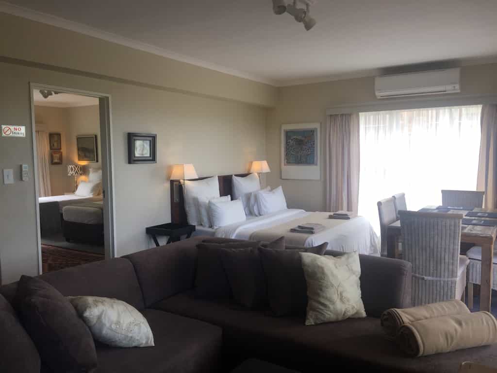 Main bedroom with king bed, open plan lounge, dining and full kitchen. Door to second bedroom to you left