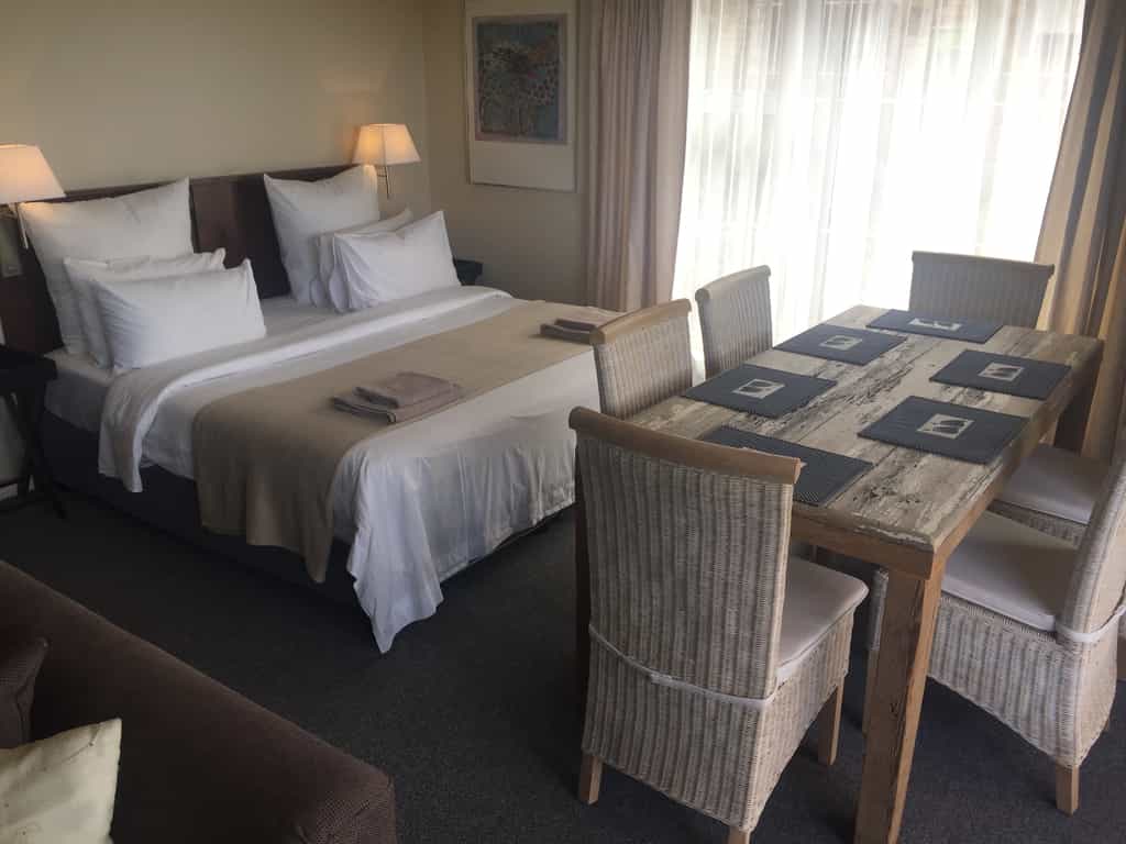 King bed in main bedroom with open plan dining and lounge area