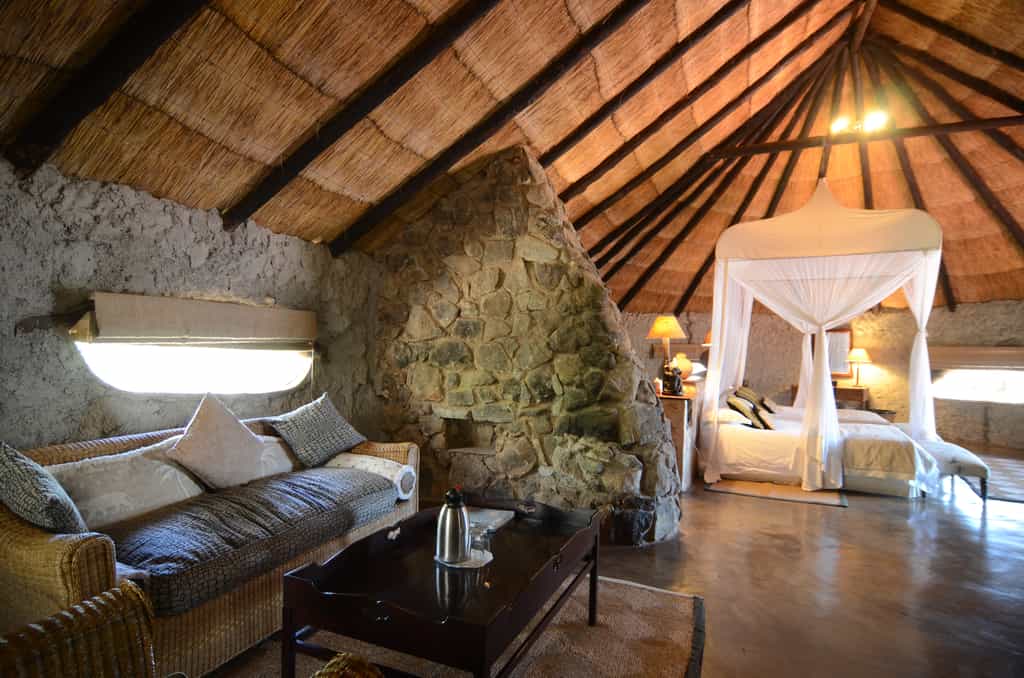 Room 3 is a Standard Family room on the ground level of Camp Amalinda and still incorporates some of the granite structures.  There are no stairs to Room 3 and it is an open plan bedroom, lounge & bathroom area with 2 double beds. The ensuite bathroom consists of a shower & bath, toilet and single rock basin. If required, there is space for an extra single bed in the family room.  Amenities include tea & coffee stations, fan, mosquito nets, mosquito coils, open wardrobe, private outside veranda, hair dryers & electric blankets.