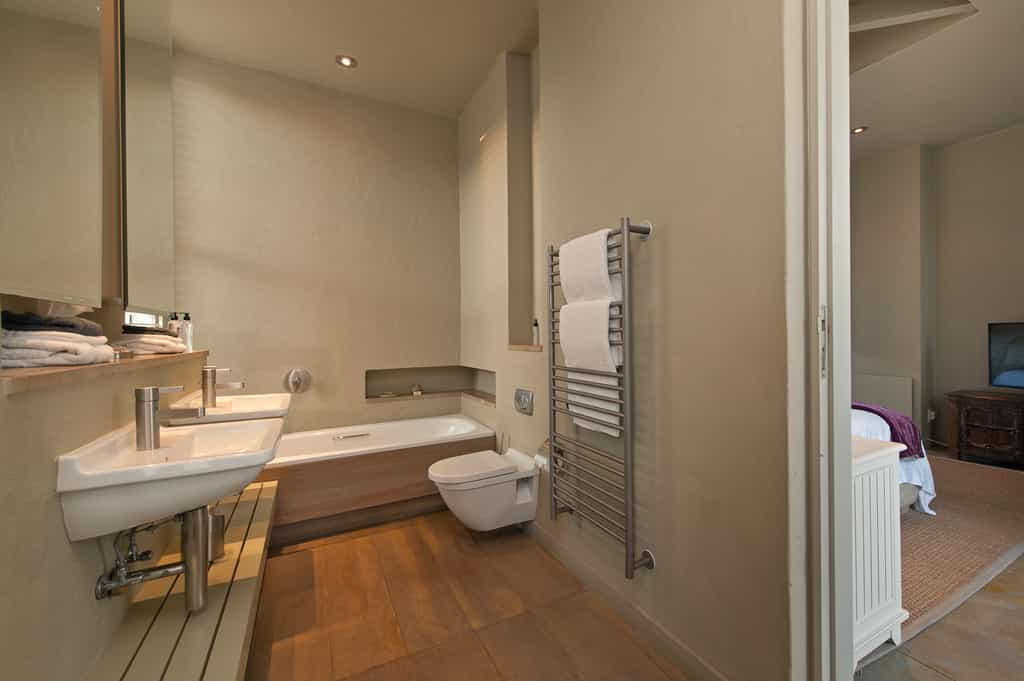 Bath, toilet and double basins in Olive deluxe bath room