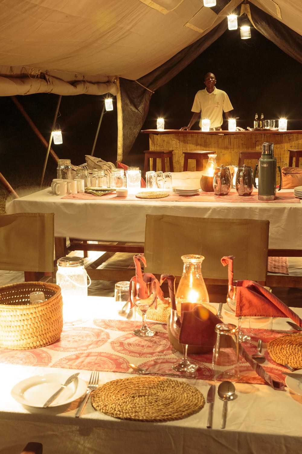 Atmospheric night-time interior of Nkonzi Camp's Swahili-style dining tent
