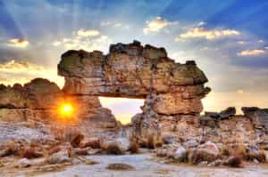 See the natural rock window that frames the sunset