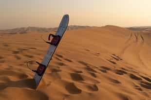 Sand board down the desert dunes of Siwa Oasis