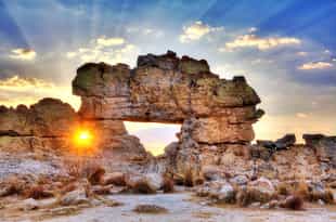 See the natural rock window that frames the sunset