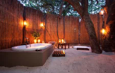 The romantic open-air bathrooms offer a unique experience. Enjoy the forest canopy with the stars peeking through as you relax in your bubble bath.