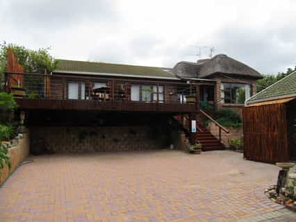 Entrance and driveway towards guest house with safe parking behind electronic gates. Lapa attached with indoor braai/fireplace and big open deck with view of river and dunes across the road.