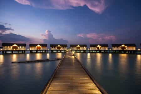 View of water villas during sunset